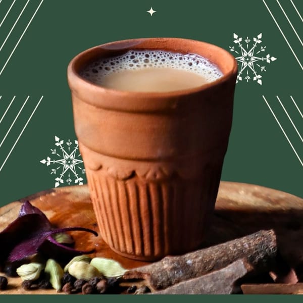 Indian chai in a traditional clay cup, surrounded by spices like cardamom and cinnamon.
