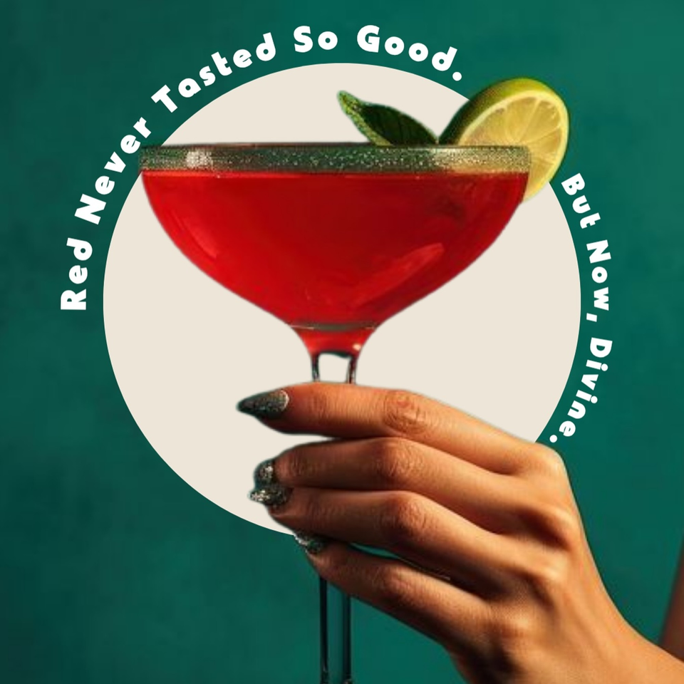 Hand holding a red cocktail with a lime wedge and mint garnish, against a green background.